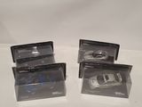 three cars in plastic bags sitting on top of a white surface