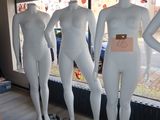 several mannequins are lined up in front of a window in a store