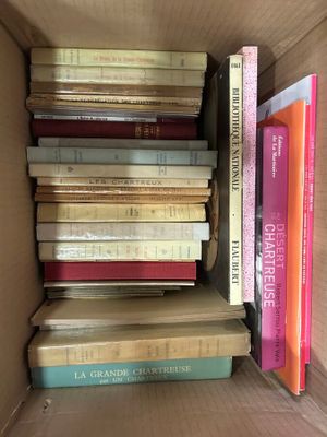 many books in a box that are stacked on top of each other