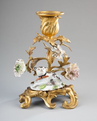 un bougeoir en or orné d'un chien et de fleurs