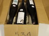 three bottles of wine in a cardboard box on a table