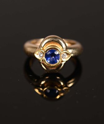 gros plan d'une bague en or avec un saphir et des diamants
