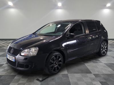 la photo d'une voiture noire garée sur un sol en damier