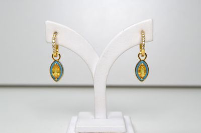 un gros plan sur une paire de boucles d'oreilles posées sur un présentoir