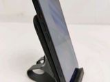 a close up of a cell phone on a stand on a table