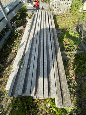 un banc en bois posé dans l'herbe, près d'une clôture