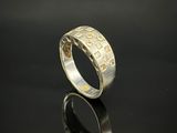 gros plan d'une bague en argent sur une surface noire