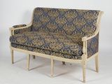 a blue and gold couch sitting on a white floor