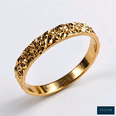 gros plan d'une bague en or sur fond blanc