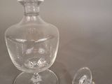 a clear glass vase and a small glass cup on a table