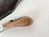 a knife that is laying on a table next to a wallet