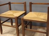 two wooden chairs sitting next to each other on a hard wood floor