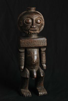 une statue en bois représentant un homme avec un crâne sur la tête