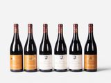six bottles of red wine lined up in a row