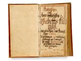 un vieux livre sur lequel on peut lire des mots, ouvert sur une surface blanche