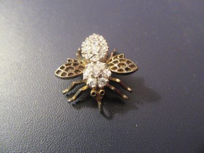 une broche en forme d'abeille en or et diamants sur un fond noir