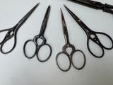 five pairs of scissors sitting on a table next to each other