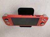 a pink nintendo wii game system on a white surface