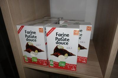 trois boîtes de conserves posées sur une étagère dans une cuisine