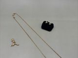 a gold necklace and a black purse sitting on top of a table