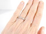 a woman ' s hand with a diamond ring on it