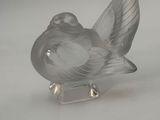 a glass bird that is sitting on top of a table