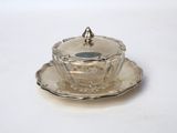 a silver cup and saucer on a saucer