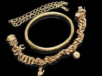 un bracelet en or, un bracelet et une bague sur fond noir