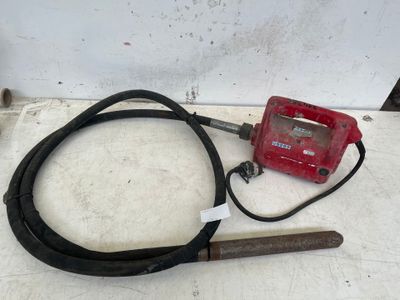 a red radio and a black cord on the floor