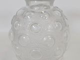 a glass vase that is sitting on a white surface