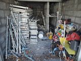 un tas de bric-à-brac dans un garage, à côté d'un tas d'outils