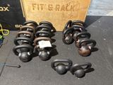 de nombreux kettlebells posés par terre à côté d'une caisse