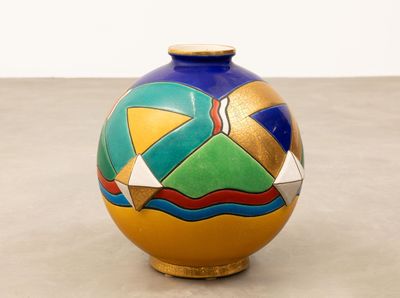 un vase coloré posé sur une table, sur fond blanc