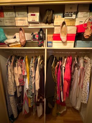 une armoire sur laquelle sont posés beaucoup de vêtements et de chaussures