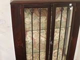 a glass display cabinet with a wooden top and glass doors