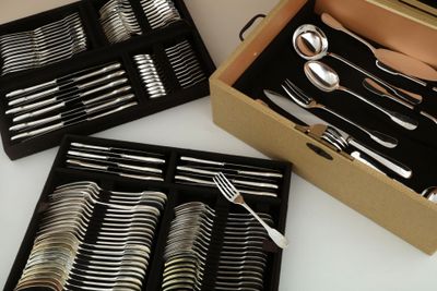 une grande quantité d'argenterie dans une boîte posée sur la table