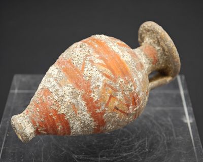 un petit objet en poterie posé sur une surface claire