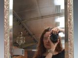 a woman taking a picture of herself in a mirror