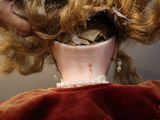 a doll that has a cup in it ' s mouth