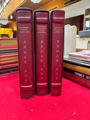 three books that are sitting on a red carpet