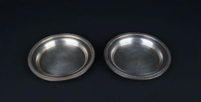 deux assiettes en argent sur fond noir