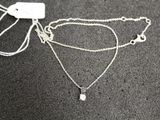 a close up of a silver necklace with a chain attached to it