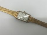 an image of a gold wrist watch on a white surface