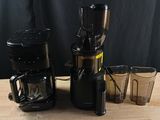 a blender and cups sitting on a table with a black background
