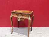 a small wooden table with a red wall in the background
