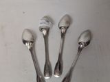 four silver spoons sitting on top of a white table