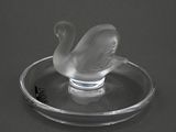 un cygne en verre posé sur une assiette en verre