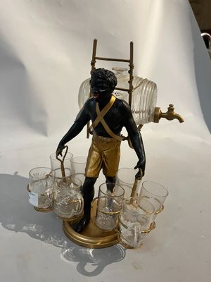 une figurine représentant un homme tenant une échelle et des verres