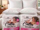 two boxes of calin pillows on a bed in a bedroom