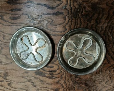 two metal pans sitting on a wooden table